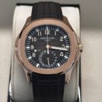 Luxury Patek Philippe Aquanaut Travel Time in rose gold with dual time zone display and black rubber strap, elegantly presented in display box
